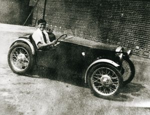 A Photo of a young John Haynes sitting in a Austin 7